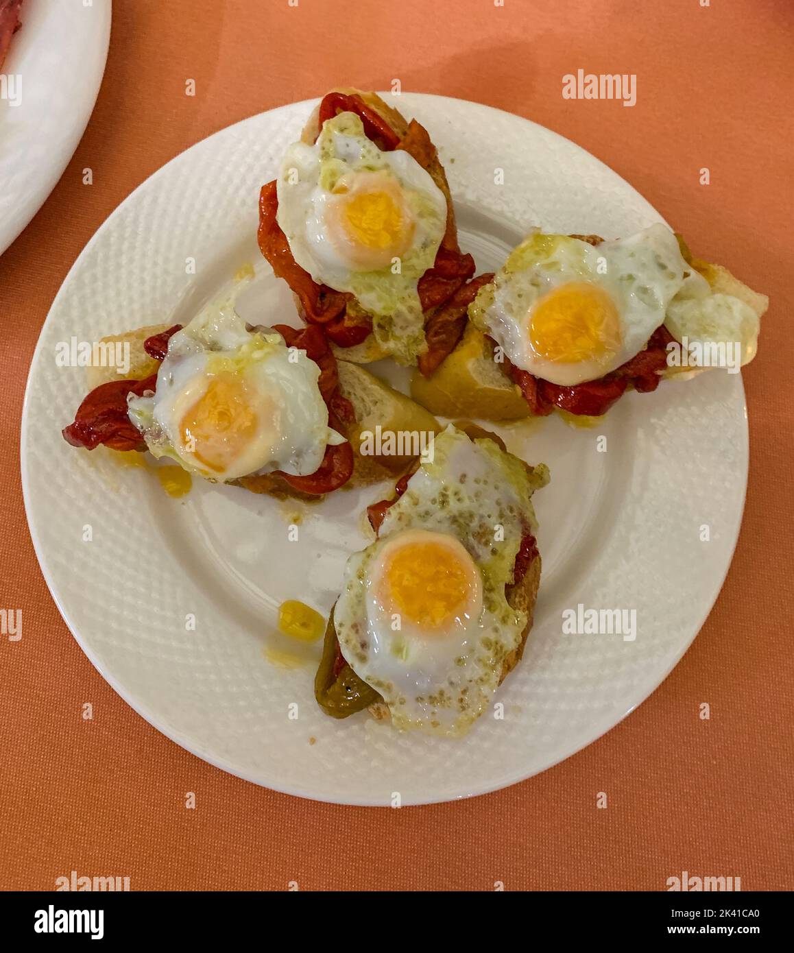 Spanien, Spanische Küche. Wachteln Sie Eierpapas auf Brot mit roten Paprika. Stockfoto