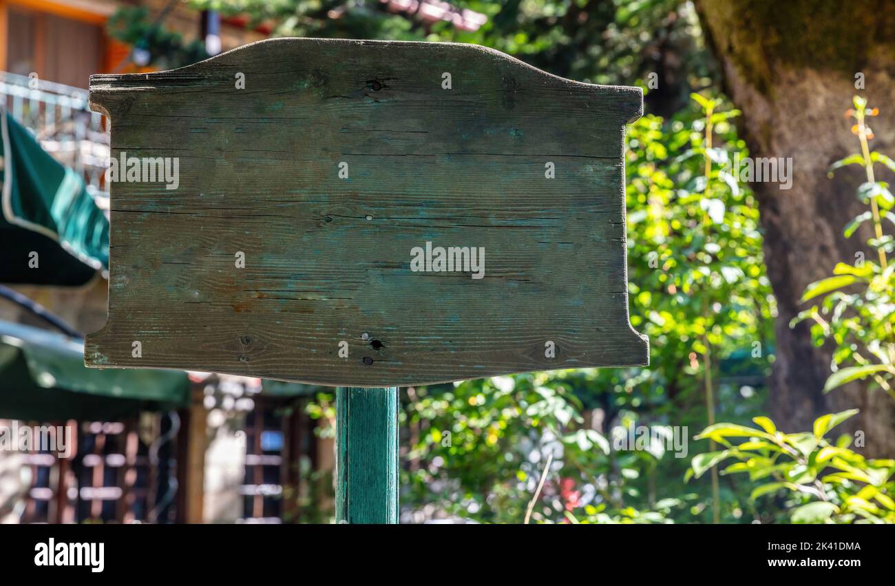 Holz vintage leere Schild auf Stange für Text oder Werbung, auf Unschärfe Natur und Gebäude Hintergrund. Leerer Wegweiser, Plakatwand, Kopierraum Stockfoto
