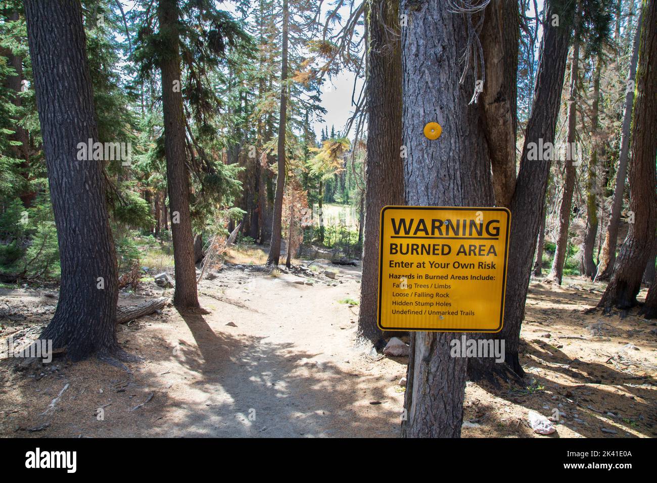 Ein Schild am Kings Creek Falls Trailhead im Lassen Volcanic National Park warnt vor potenziellen Gefahren nach dem Dixie-Brand von 2021. Stockfoto