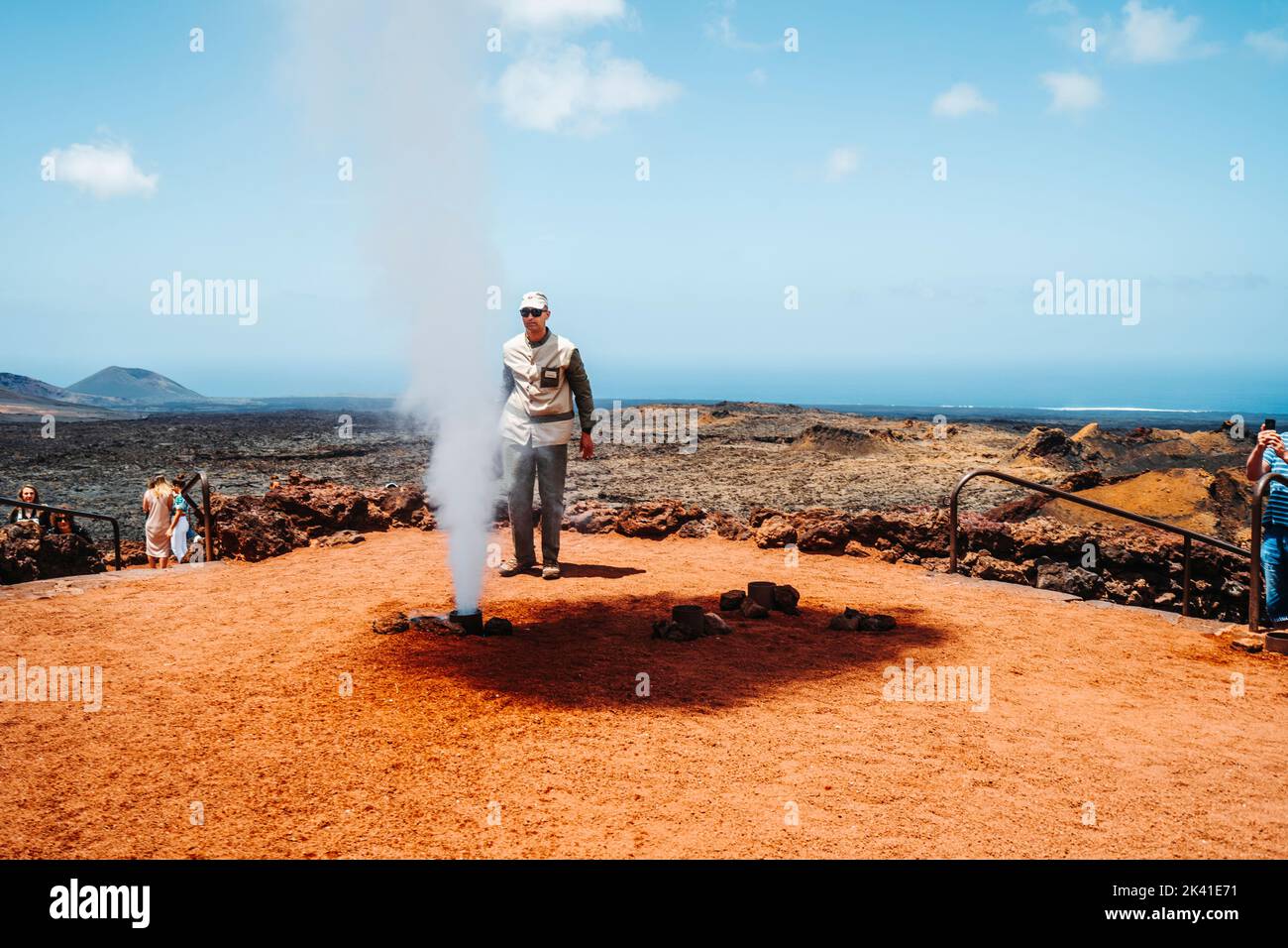 Timanfaya National Park, Spanien - 24. April 2022: Ranger demonstriert die Hitze des Vulkans, indem er Wasser gießt, das sofort zum Dampf wird Stockfoto