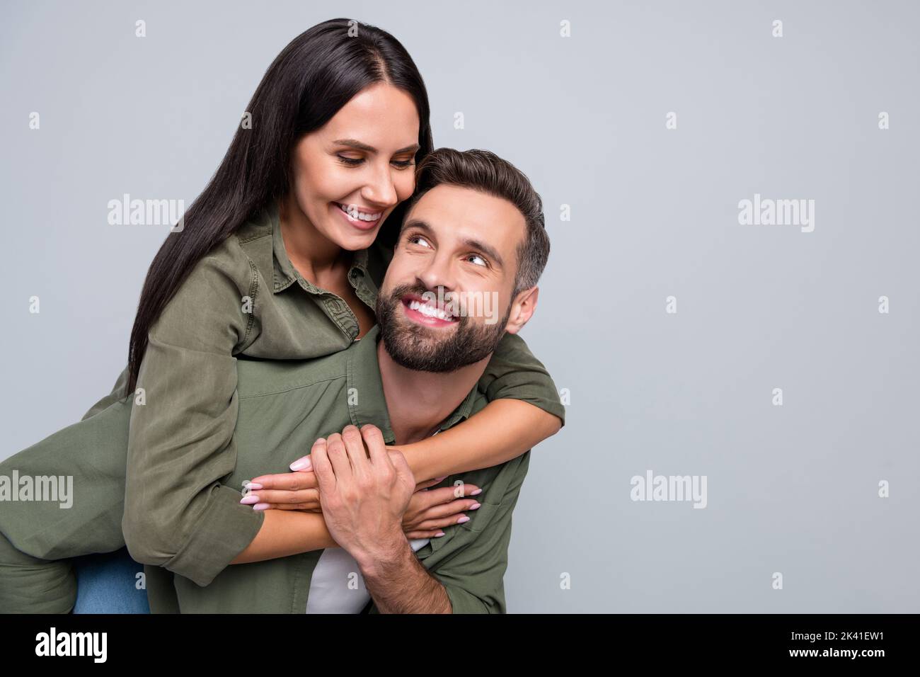 Portrait von attraktiven fröhlich amorous vorsichtig Paar umarmt mit Spaß Piggy Unterstützung isoliert über grauen Pastellfarben Hintergrund Stockfoto