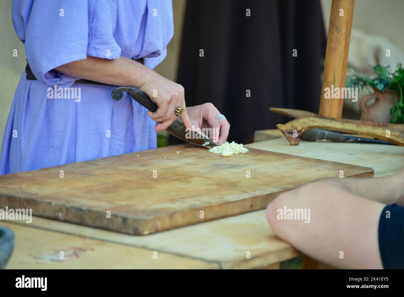 Der Koch schneidet die Zwiebeln auf einem Holzbrett Stockfoto