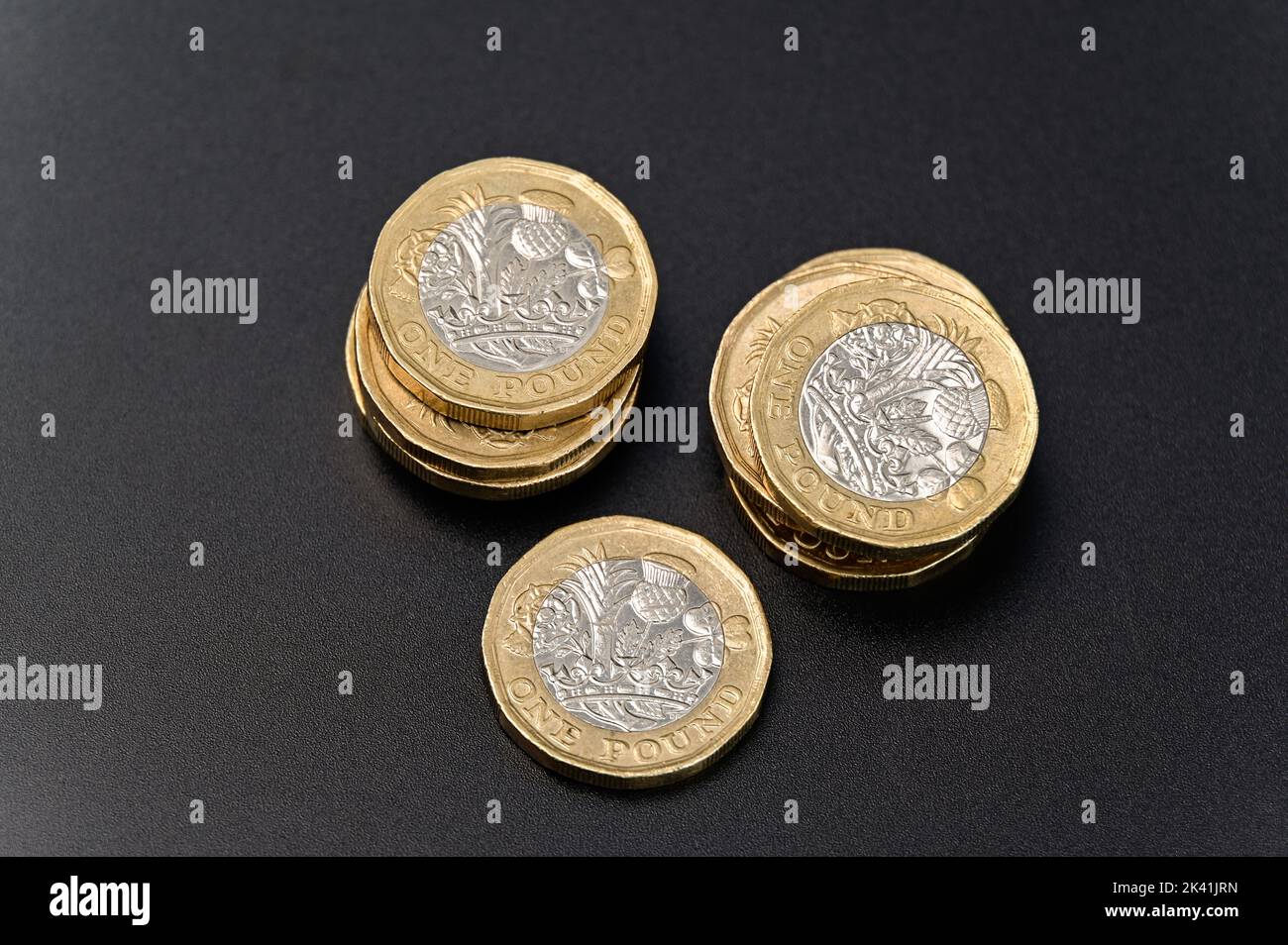 Britische 1-Pfund-Münzen in GBP Währung Geld auf schwarzem Hintergrund Stockfoto