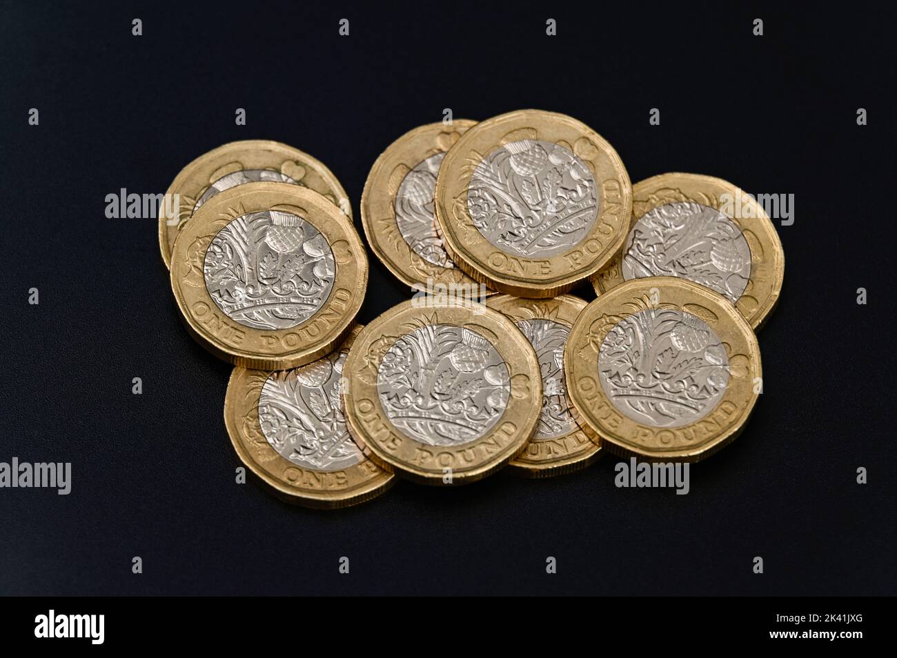 Britische 1-Pfund-Münzen in GBP Währung Geld auf schwarzem Hintergrund Stockfoto