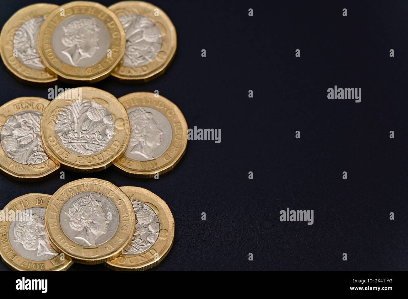 Britische 1-Pfund-Münzen in GBP Währung Geld auf schwarzem Hintergrund Stockfoto
