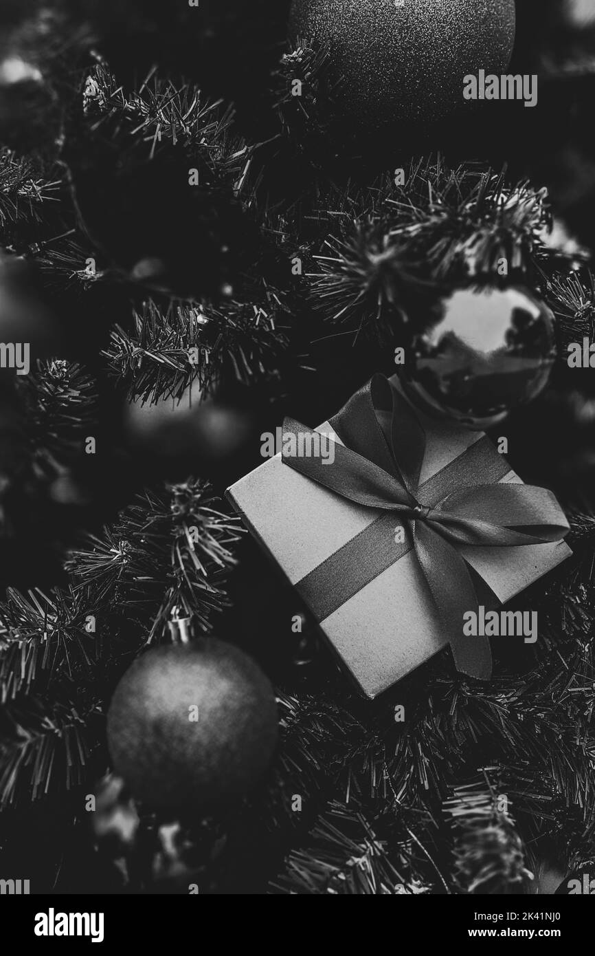 Weihnachtliche minimalistische Komposition in monochromer Form. Weihnachtsbaum Geschenke, Dekorationen auf schwarzem Hintergrund. Stockfoto
