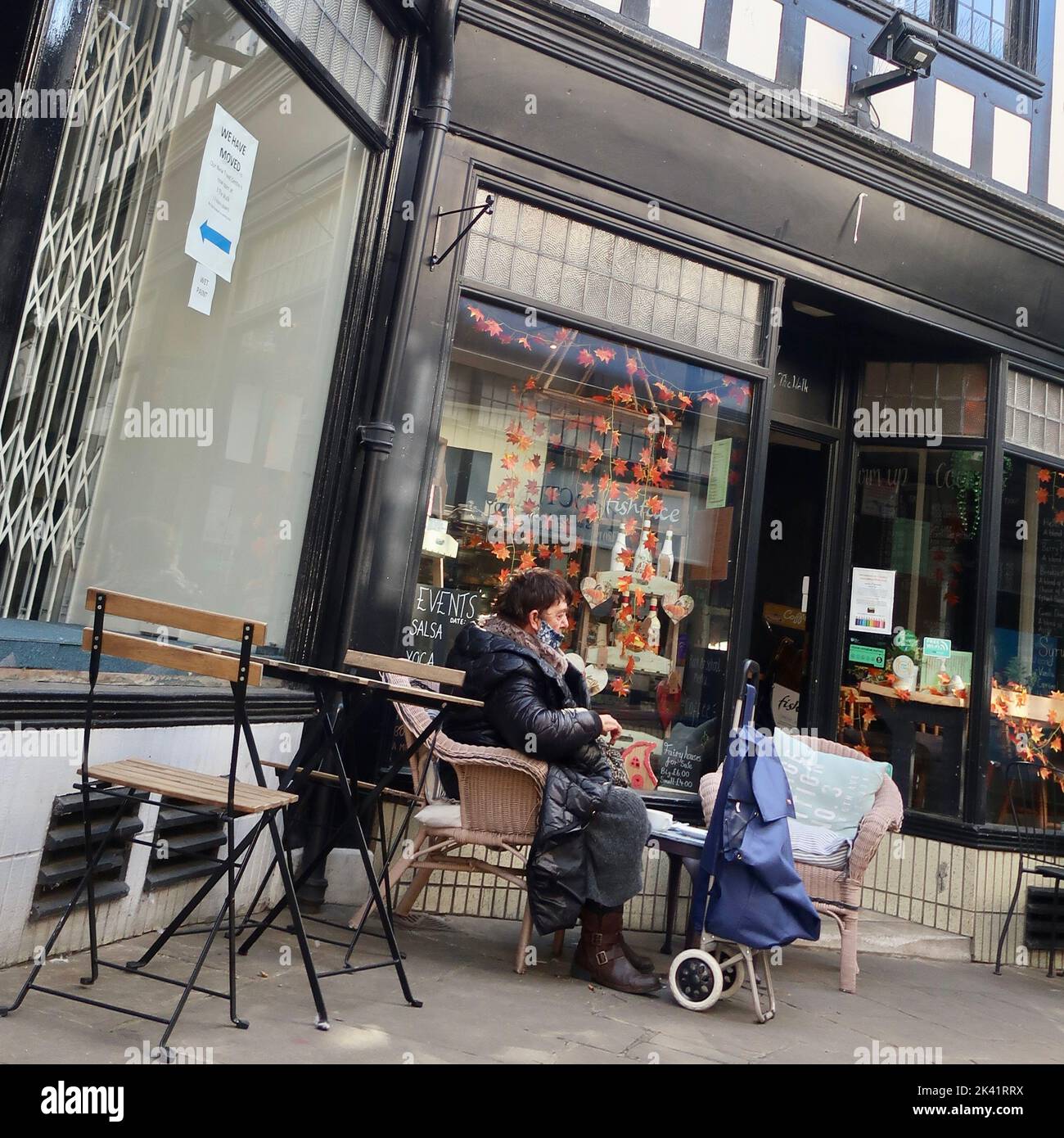 Ipswich, Suffolk, Großbritannien - 29. September 2022 : strahlender sonniger Herbstnachmittag im Stadtzentrum. Eine Frau, die sich vor einem Café ausruhte. Stockfoto