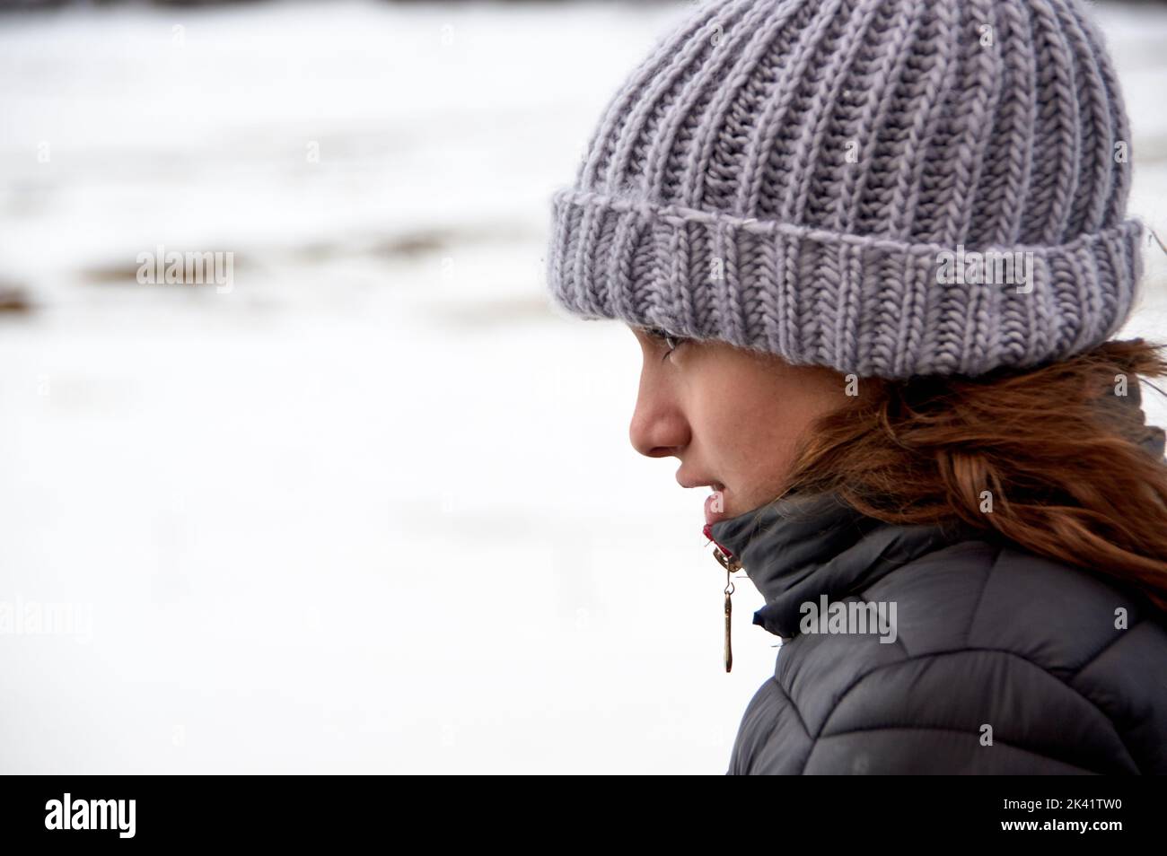 Porträt des Profils einer jungen Frau im Winter. Stockfoto