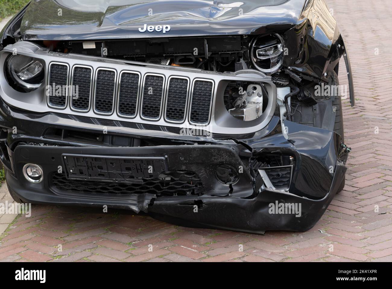 Jeepwagen mit Frontalschaden durch einen Autounfall, schwarzes Geländefahrzeug mit gebrochenem Stoßfänger, Scheinwerfer, verbogene Motorhaube. Stockfoto