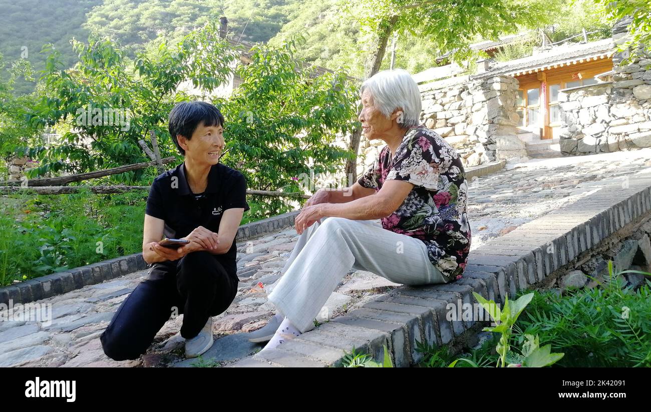 Taiyuan. 29. September 2022. Liu Guizhen (L) chattet mit einem Dorfbewohner in der nordchinesischen Provinz Shanxi, 6. Juli 2022. SO GEHEN SIE ZU „Profil: Eine Parteisekretärin, die ihr Dorf gewechselt hat“ Credit: Xinhua/Alamy Live News Stockfoto