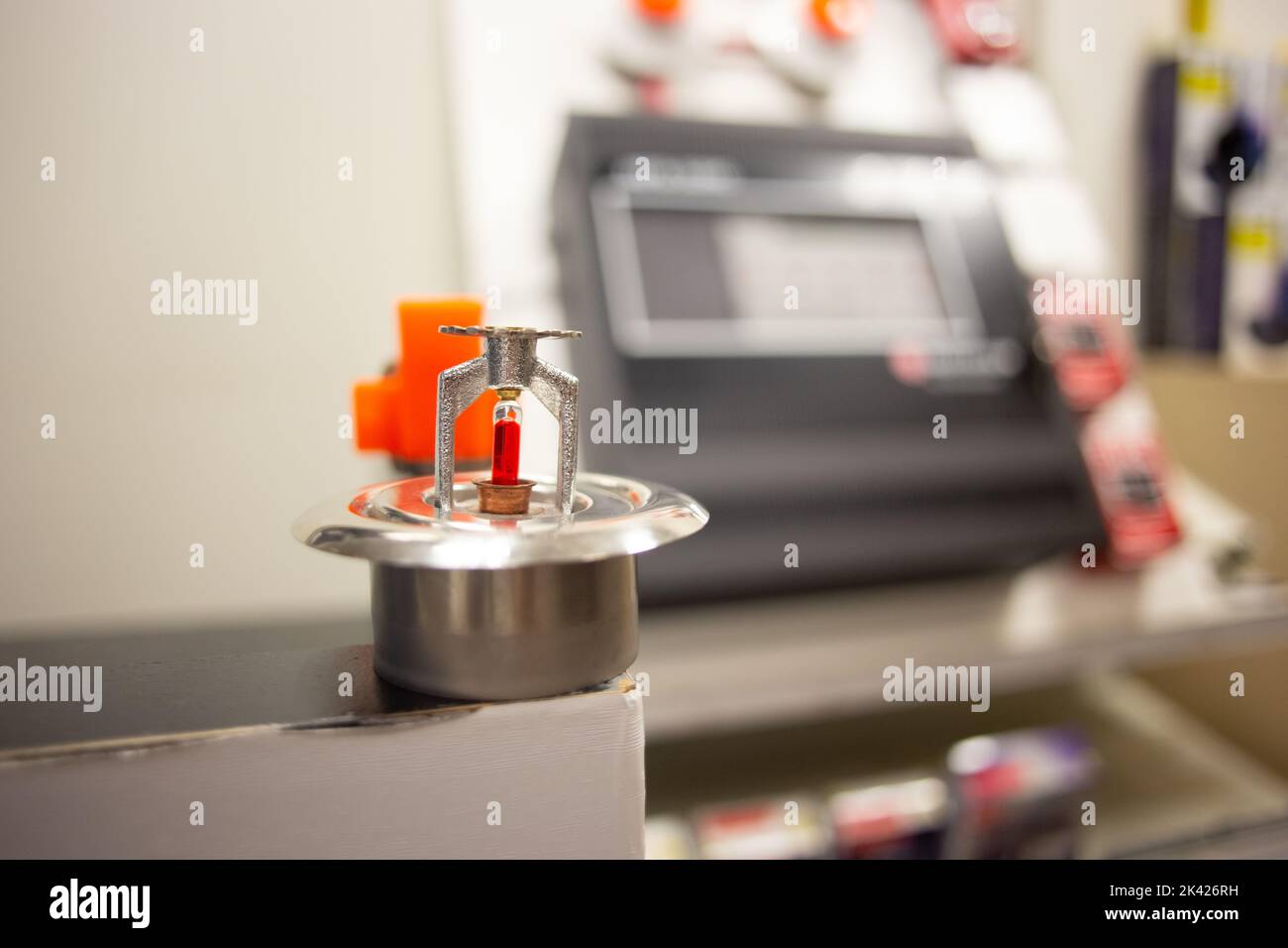 Feueralarm und Scheinsprinkleranlage, die an einer weißen Wand befestigt ist, die für Schulungen verwendet wird Stockfoto