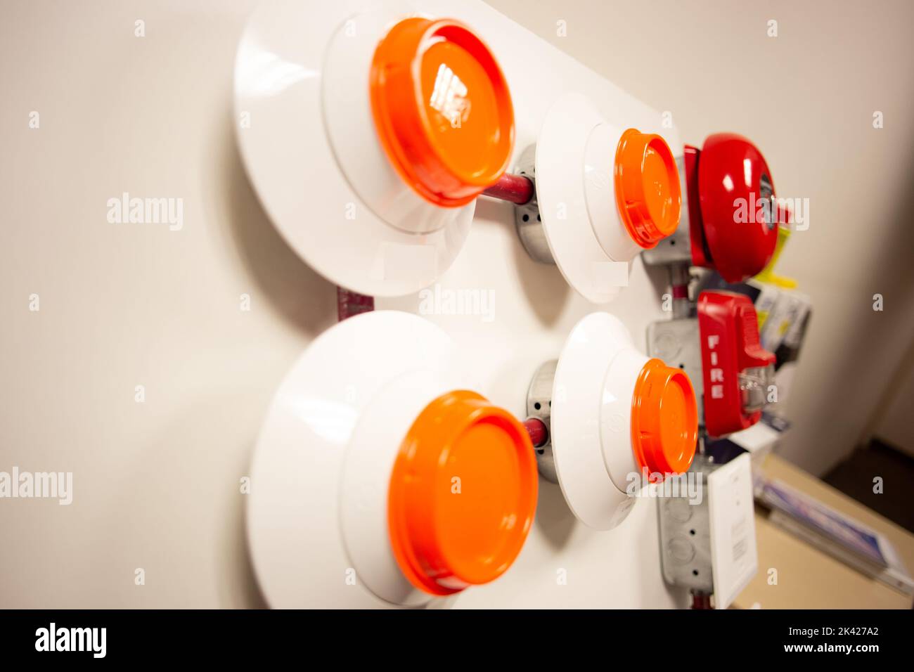 Feueralarm und Scheinsprinkleranlage, die an einer weißen Wand befestigt ist, die für Schulungen verwendet wird Stockfoto