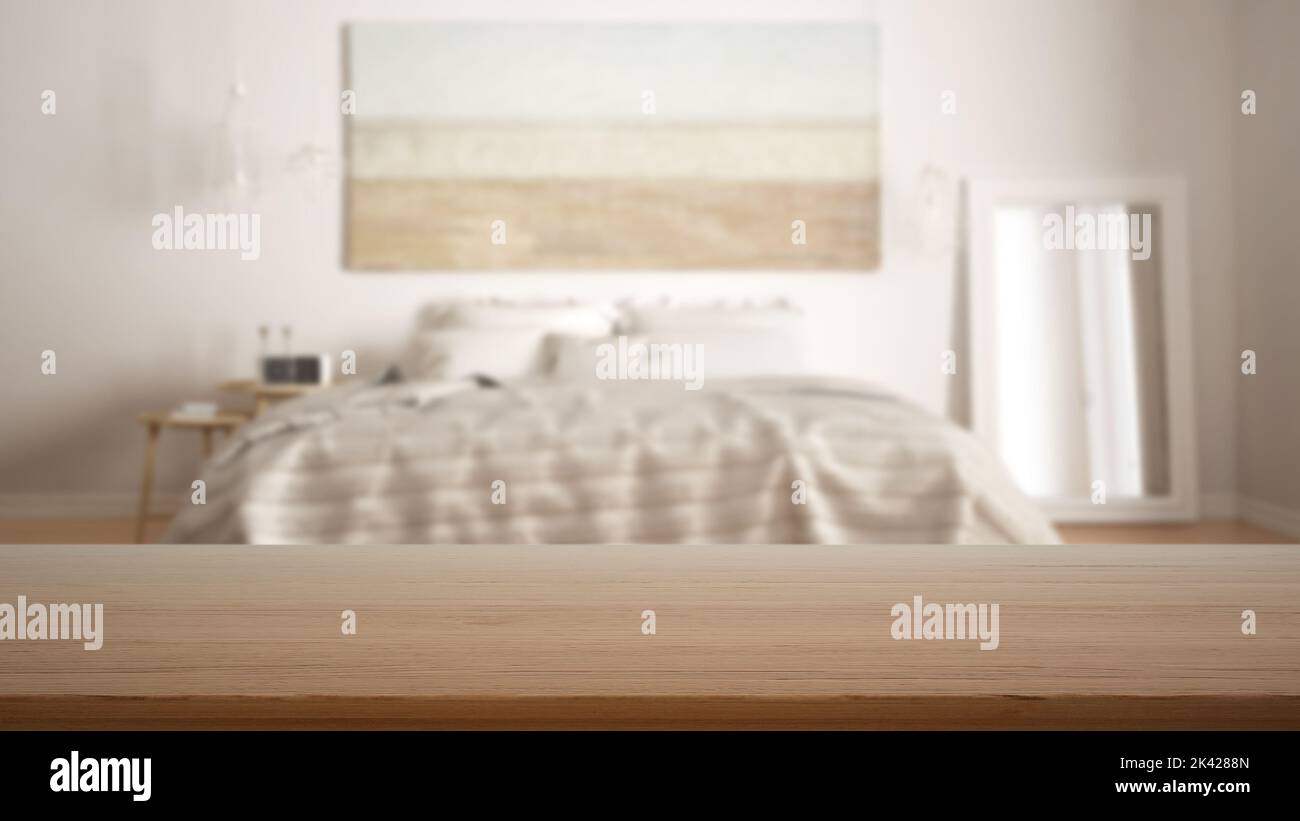 Leerer Holztisch, Schreibtisch oder Regal mit verschwommenem Blick auf das skandinavisch-weiße Schlafzimmer, Bett mit Kissen, Spiegel und Beistelltisch, moderne Inneneinrichtung Stockfoto