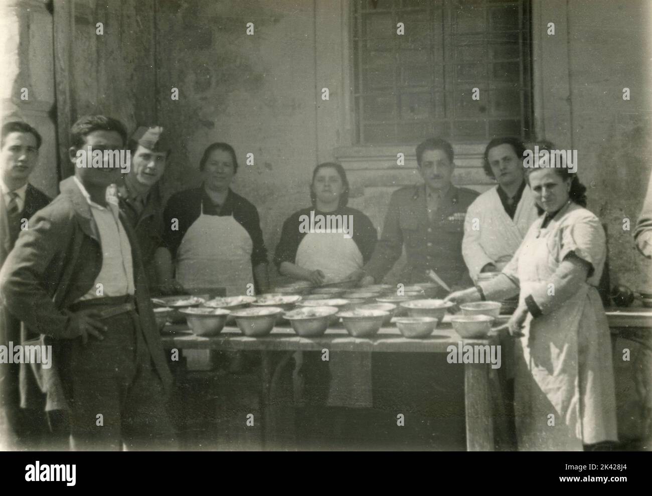 Frauen und Soldaten, die Lebensmittel für die Menschen zubereiten, Neapel, Italien 1957 Stockfoto