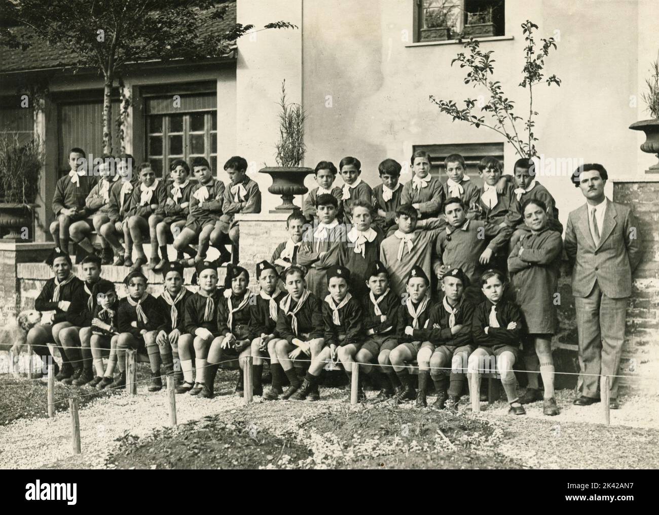Traditionelles Klassenfoto der Schüler mit Schürze und Balilla-Faschistenuniform, Italien 1920s Stockfoto