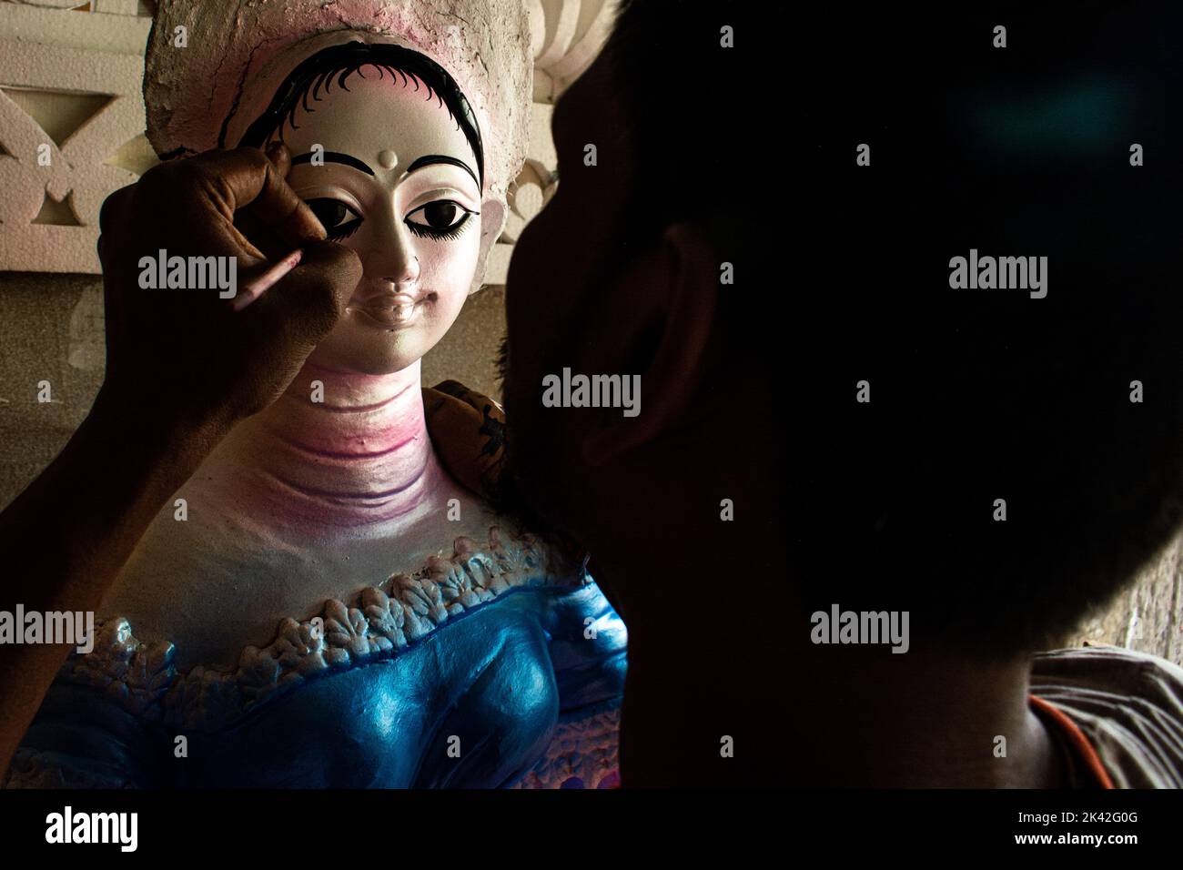 Ein Paal-Idol-Künstler, der Devi Durga die Augen für die Durga-Puja-Feier zieht. Durga Puja ist eines der weithin gefeierten hinduistischen religiösen Feste Stockfoto