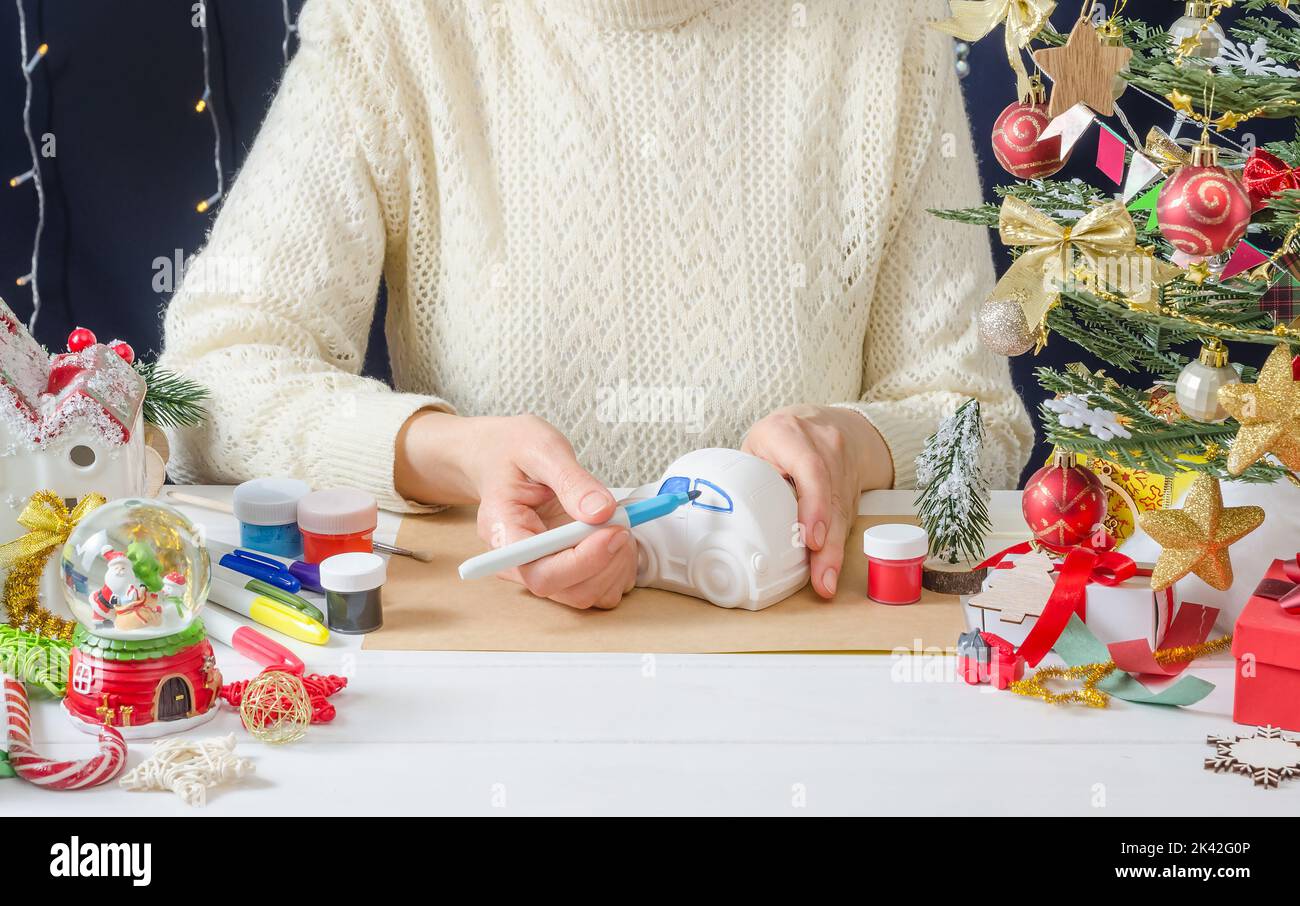 Schritt-für-Schritt Foto-Anleitung für die Weihnachtsdekoration - ein Mädchen malt die Putzmaschine, Schritt 2 - die Fenster mit dem Filzstift färben Stockfoto