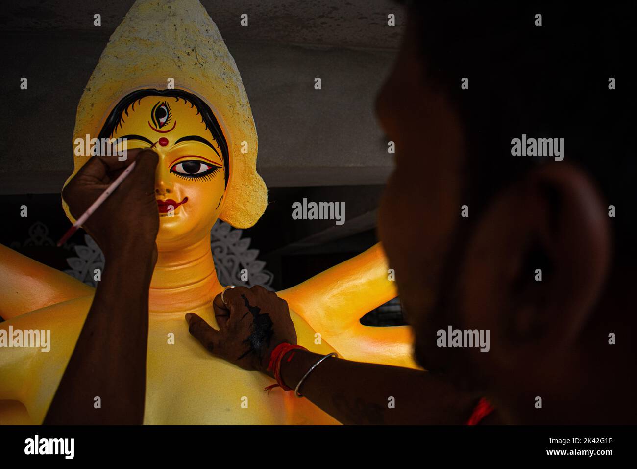 Ein Paal-Idol-Künstler, der Devi Durga die Augen für die Durga-Puja-Feier zieht. Durga Puja ist eines der weithin gefeierten hinduistischen religiösen Feste Stockfoto