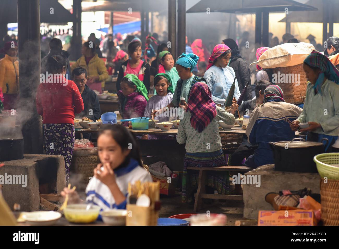 Menschen aus vietnamesischen ethnischen Gruppen tragen traditionelle Kleidung und essen in der Markthalle der Gemeinde Meo Vac, Vietnam. Stockfoto