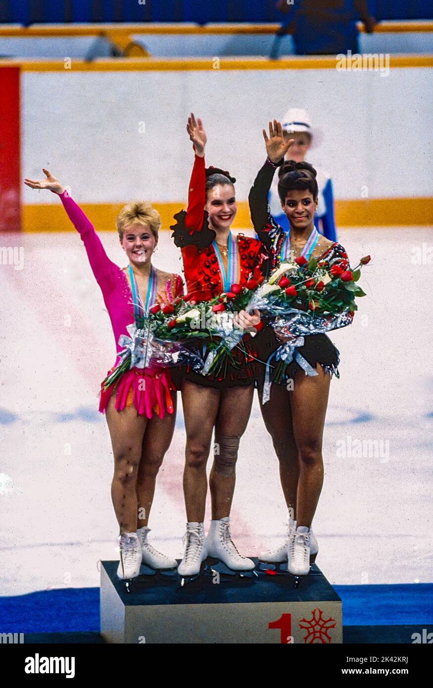 Katarina Witt (DDR) Goldmedaillengewinnerin und Olympiasiegerin mit Elizabeth Manley (CAN)-L- Silbermedaillengewinnerin und Bronzemedaillengewinnerin Debi Thomas (USA) beim Damen-Eiskunstlauf bei den Olympischen Winterspielen 1988. Stockfoto
