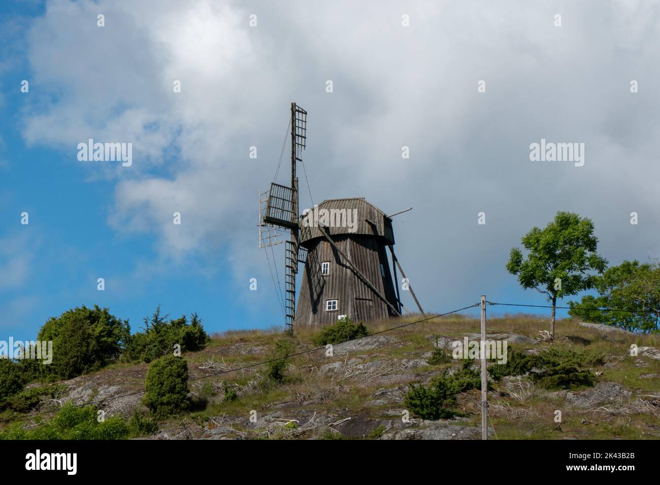 Schwedische Landschaft mit Ruine der hölzernen Windmühle Stockfoto