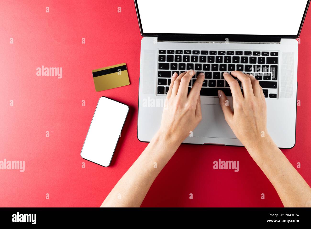 Zusammensetzung des Smartphones mit Kreditkarte und Hände mit Laptop auf rosa Hintergrund Stockfoto