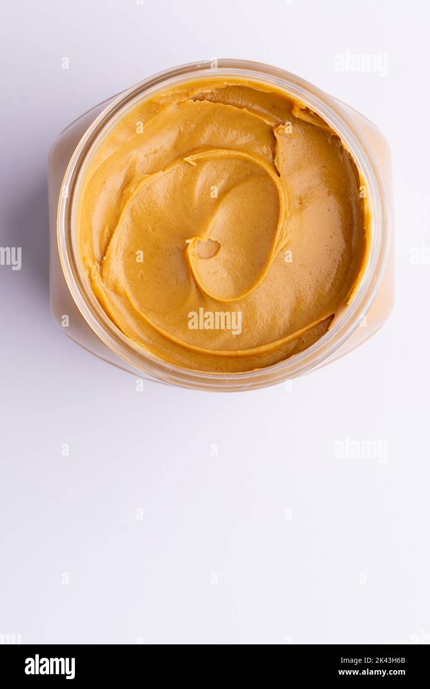 Bild eines Glases mit Erdnussbutter auf weißer Oberfläche Stockfoto