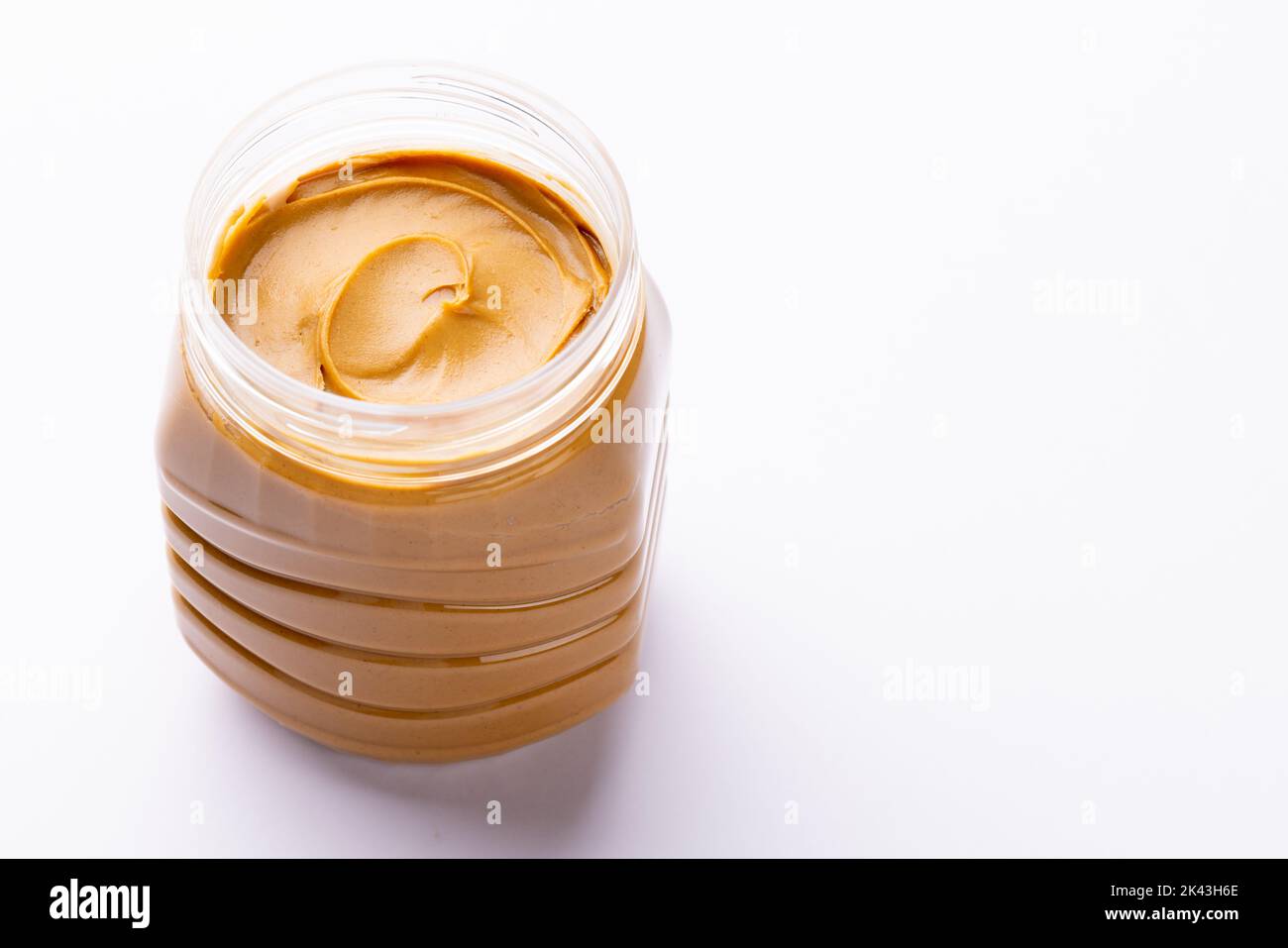 Bild eines Glases mit Erdnussbutter auf weißer Oberfläche Stockfoto