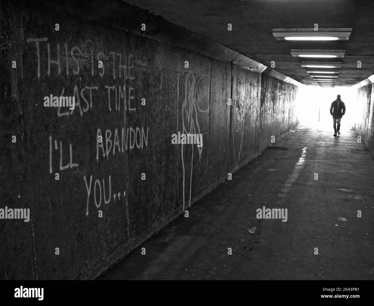 Mann, der durch einen U-Bahn-Tunnel geht, in Schwarz und Weiß, Dies ist das letzte Mal, ich werde dich verlassen Stockfoto