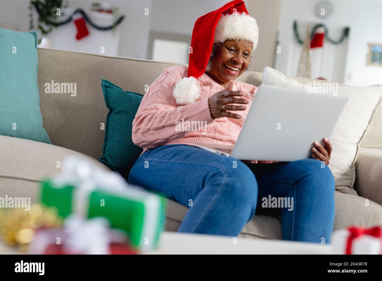 Nachdenkliche ältere afroamerikanische Frauen tragen weihnachtsmannhut und haben Gesichtszeit Stockfoto
