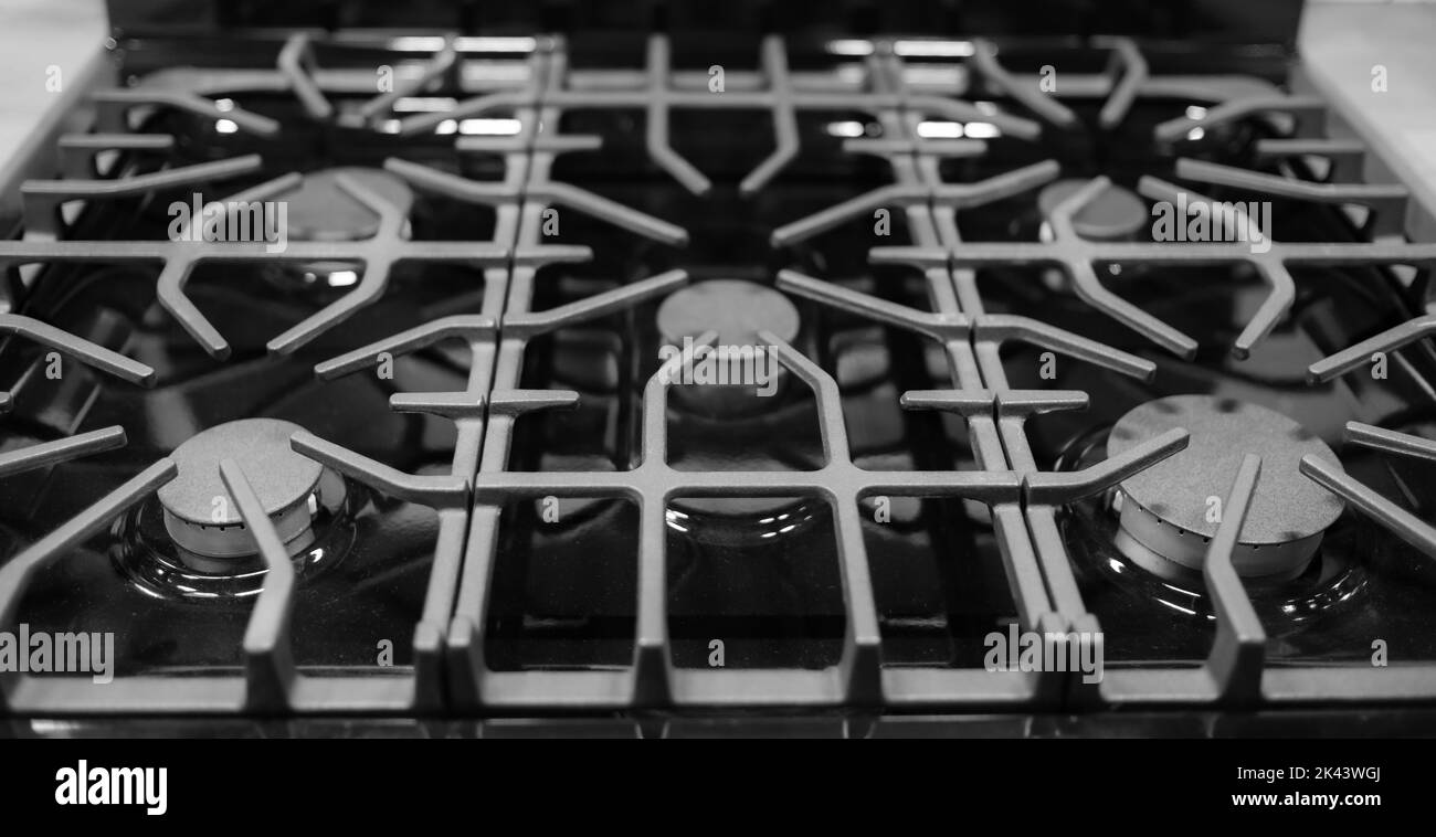 Küchenoberfläche aus Edelstahl mit gusseisernem Grill. Blick von oben. Herd Kochen Küche Herd Metall-Brenner Gas Küche Elektro-Heißkochfeld Stockfoto