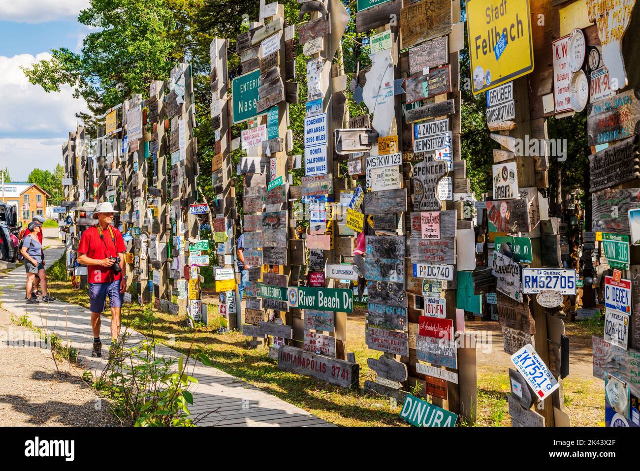 Reisende posten über 100.000 Schilder am Watson Lake Sign Post Forest; Watson Lake; Yukon Territories; Kanada Stockfoto