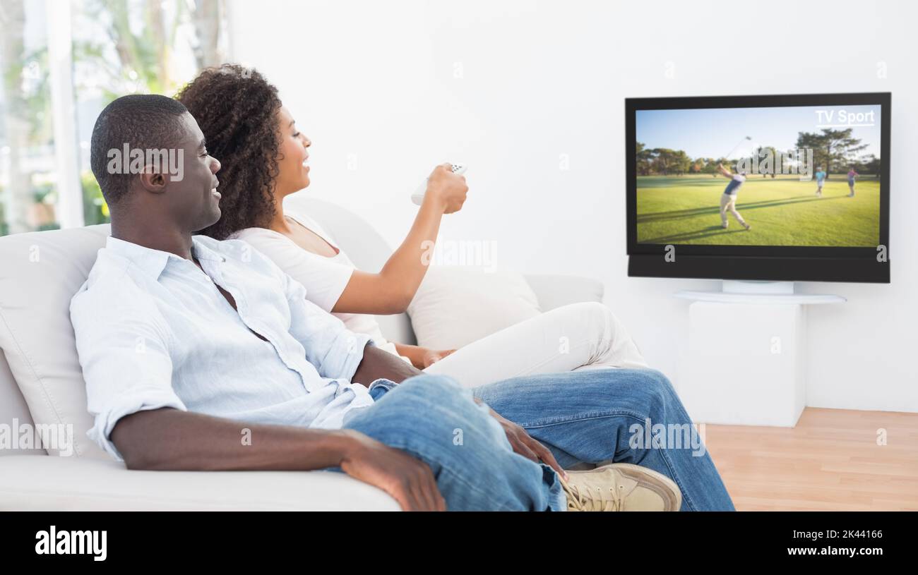 Paar sitzt auf der Couch zusammen Fernsehen zu Hause im Wohnzimmer Stockfoto