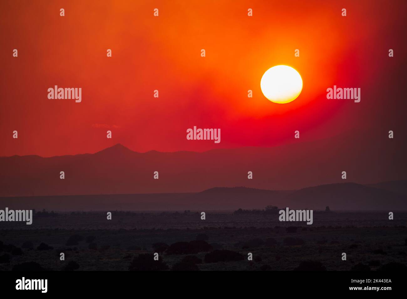 USA, New Mexico, Santa Fe, Rauch von Wildfire und Sonnenuntergang über Wüstenlandschaft Stockfoto