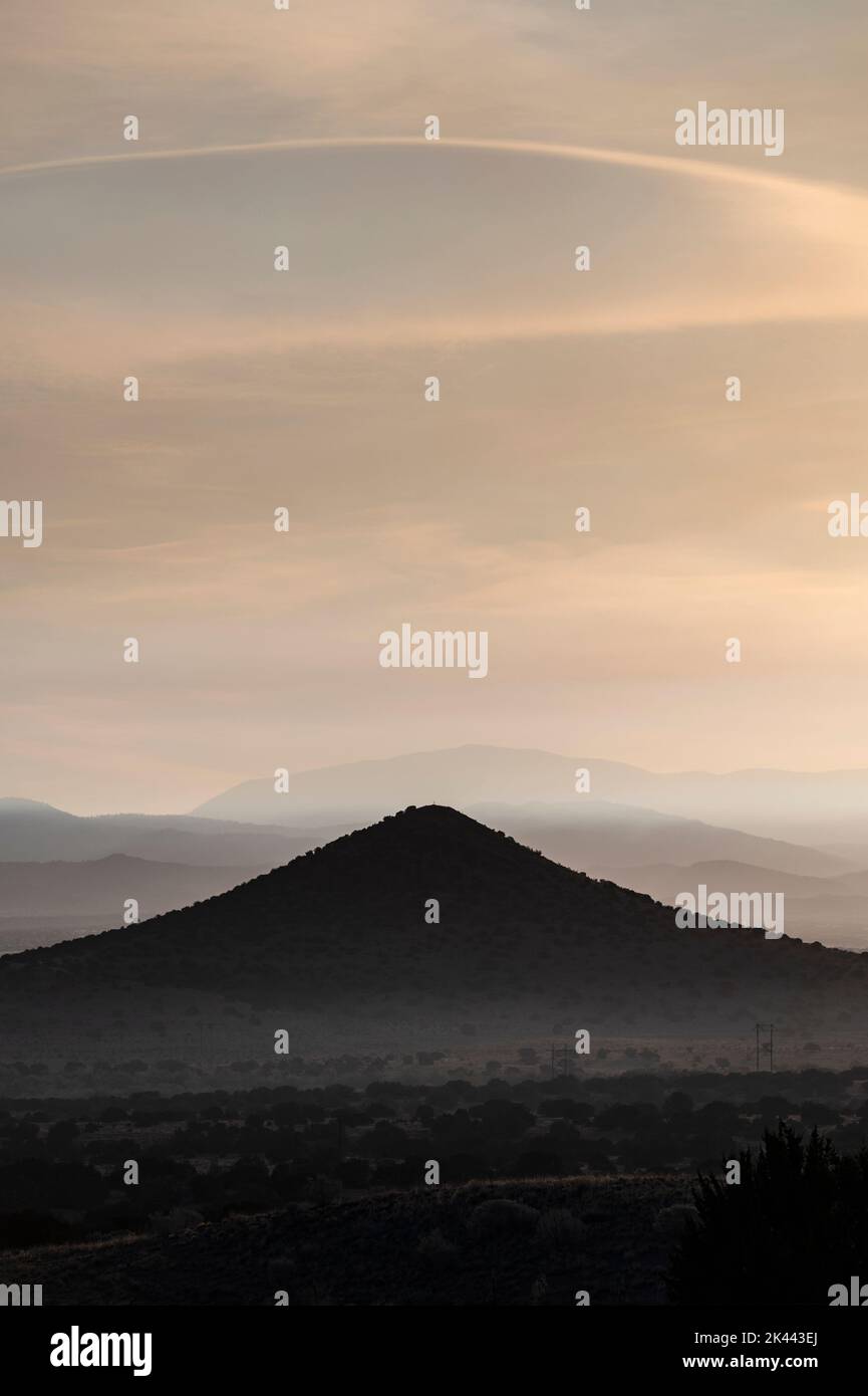 USA, New Mexico, La Ceinega, Smoke, der den Himmel am frühen Morgen über den Sangre de Cristo Mountains bedeckt Stockfoto