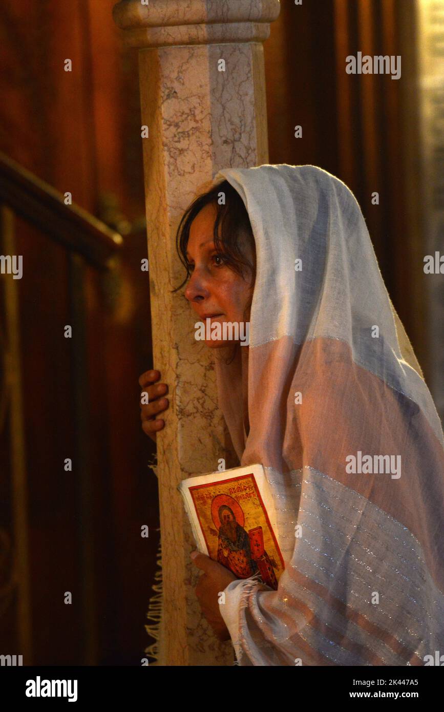 Eine Frau zündete Kerzen in der Kirche des heiligen Grabes in der Altstadt von Jerusalem, Israel. Stockfoto