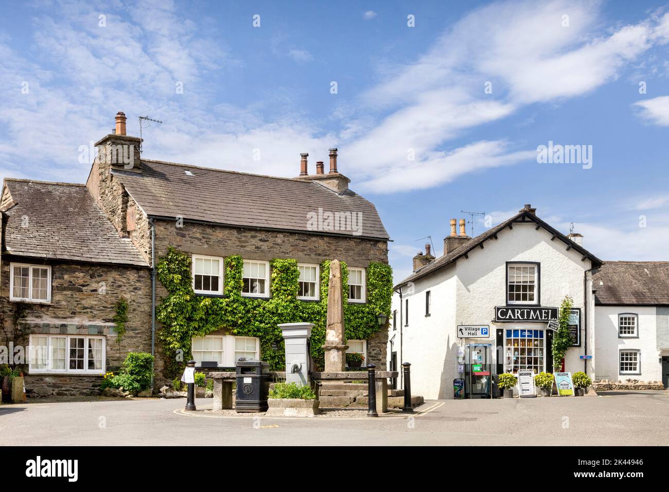 17. Mai 2022: Cartmel, Cumbria, UK - der Marktplatz und das alte Marktkreuz. Das Dorf ist berühmt als die Heimat von klebrigem Kaffeepudding, verfügbar Stockfoto