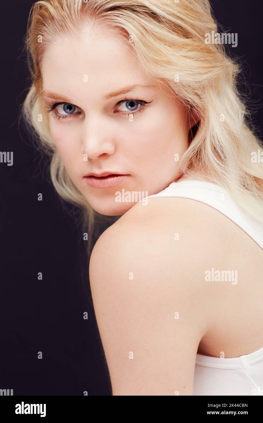 Blasse Perfektion. Porträt einer schönen Blondine isoliert vor einem dunklen Hintergrund. Stockfoto