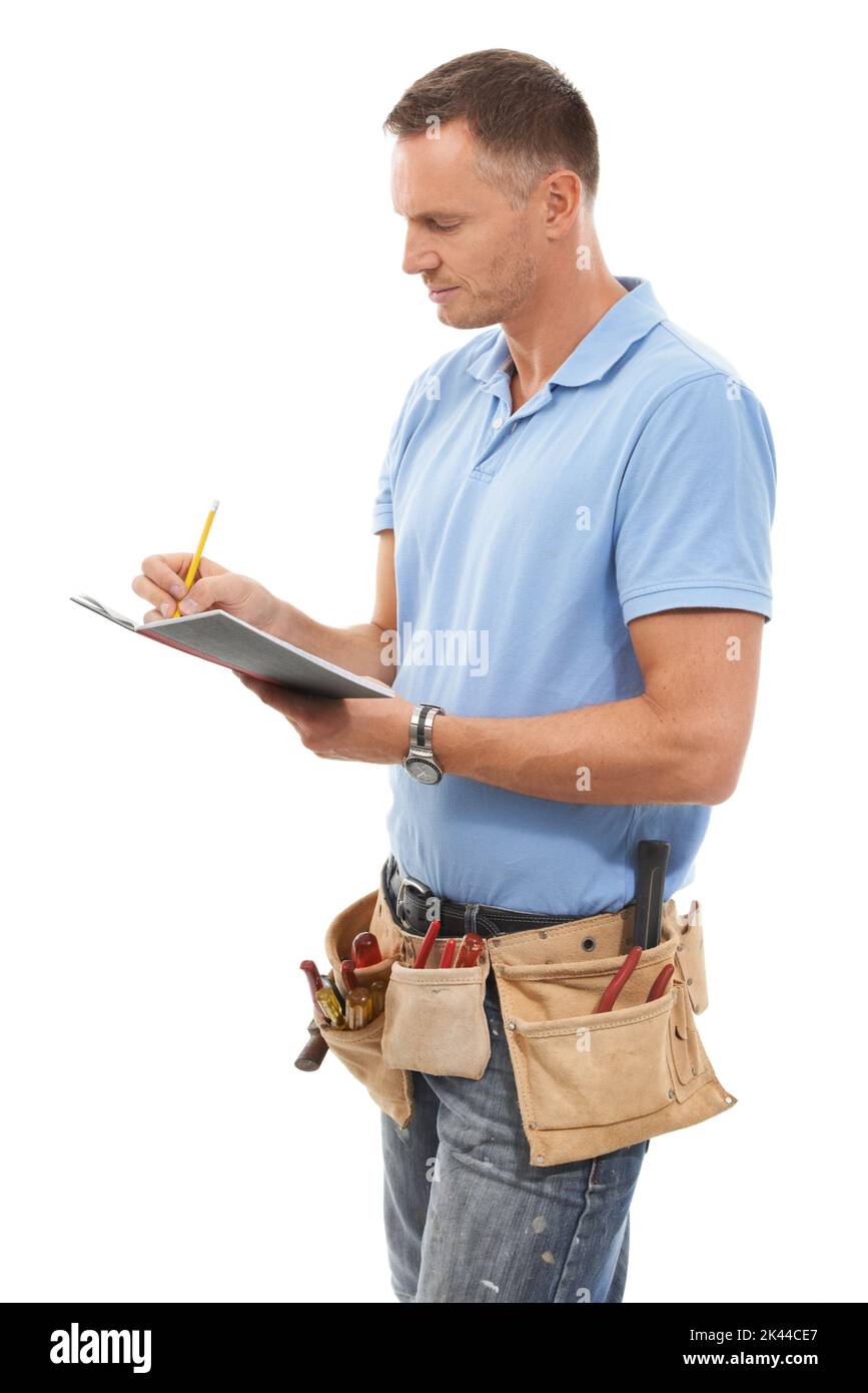Die Dimensionen nehmen. Ein reifer Mann, der einen Werkzeuggürtel trägt und ein Notizbuch vor einem weißen Hintergrund hält. Stockfoto