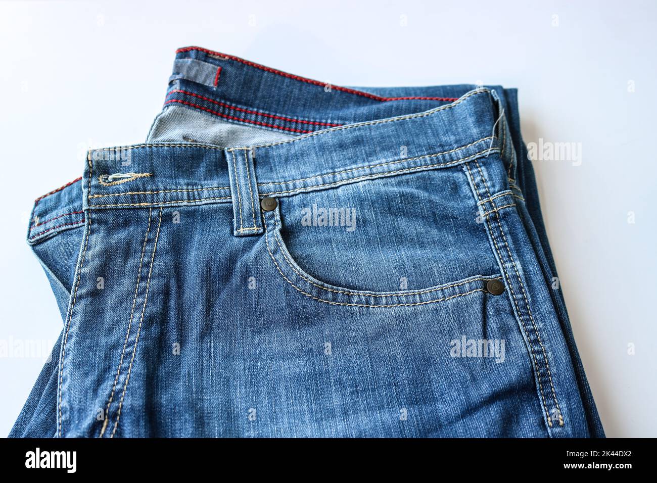 Fragment einer Jeans mit einer Tasche. Lässige Kleidung. Ursprünglicher Hintergrund für das Design. Stockfoto