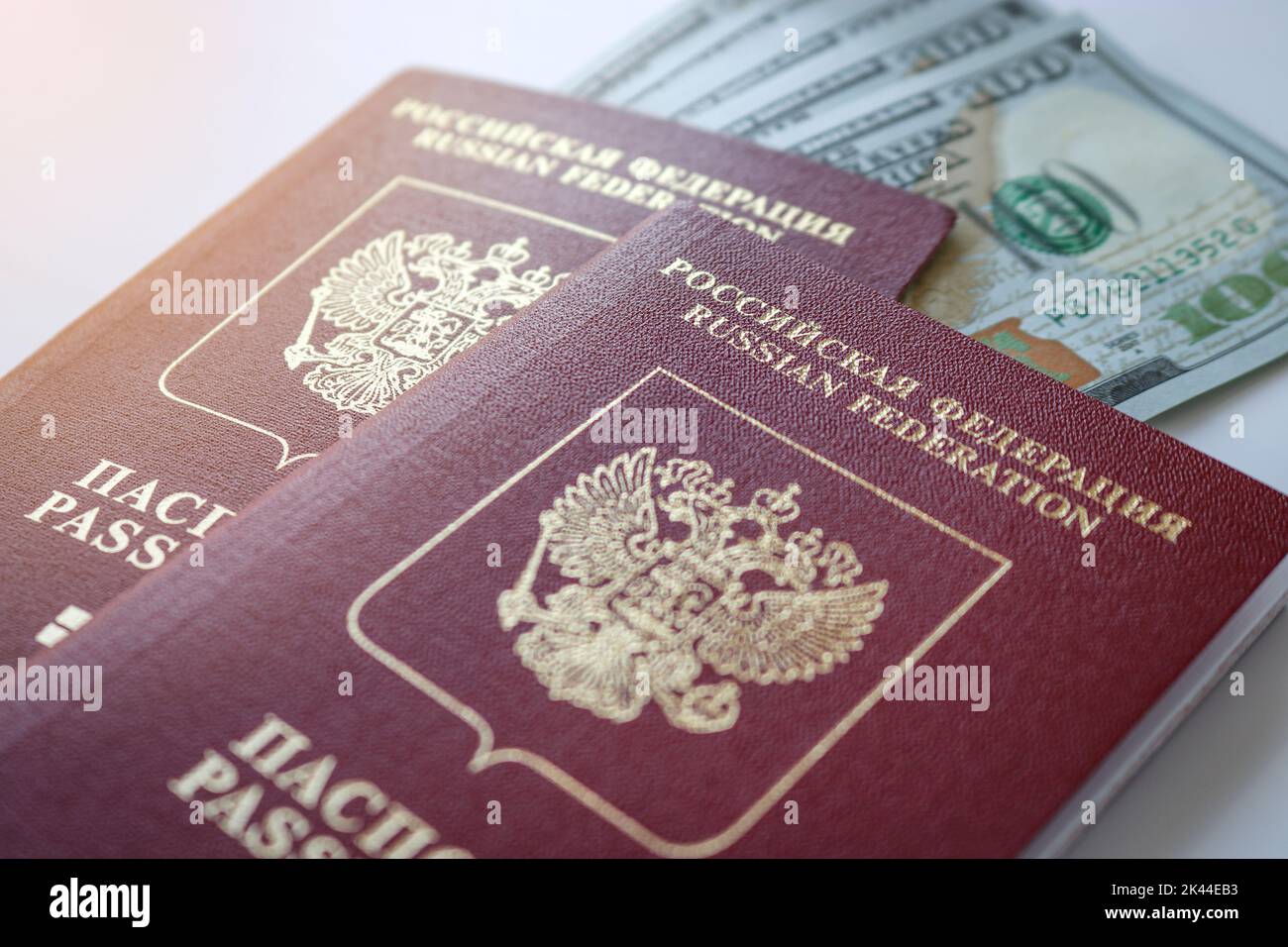 Zwei internationale russische Pässe und ein Stapel amerikanischer Dollar. Reisekonzept. Stockfoto