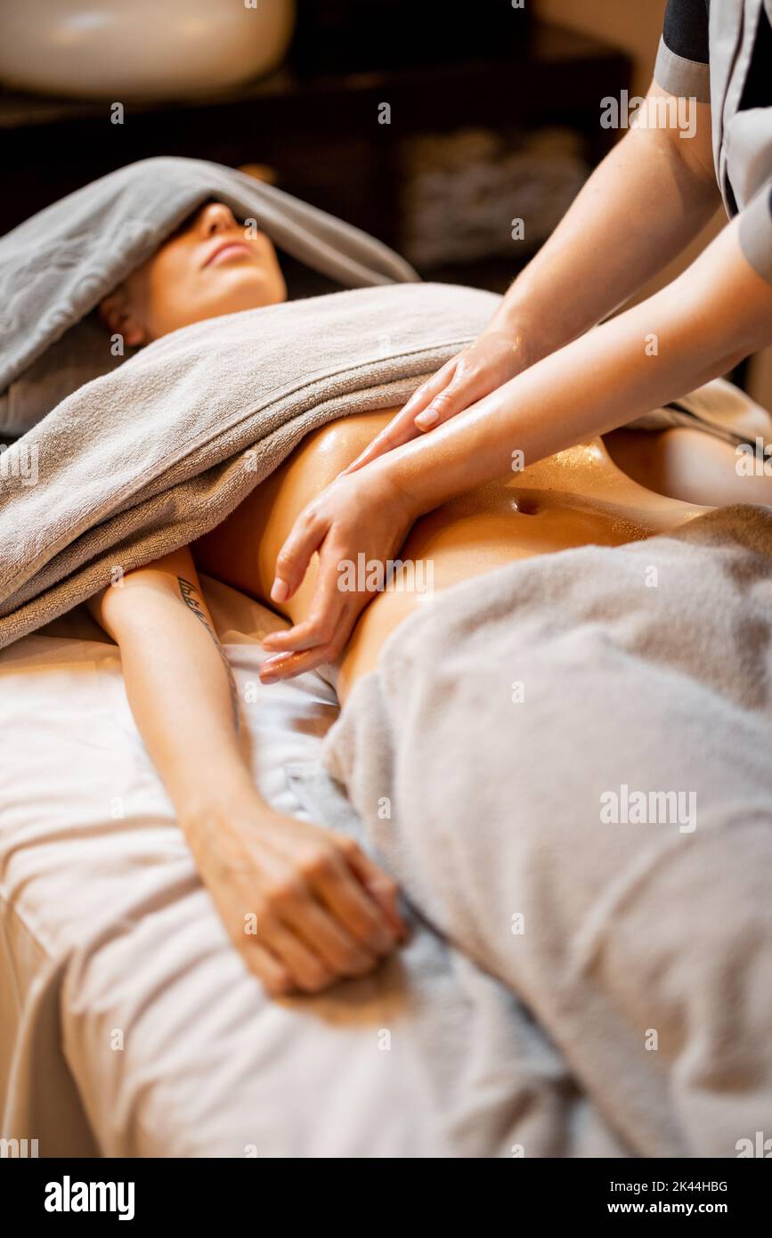 Masseuse führt eine professionelle Bauchmassage für eine Frau durch Stockfoto