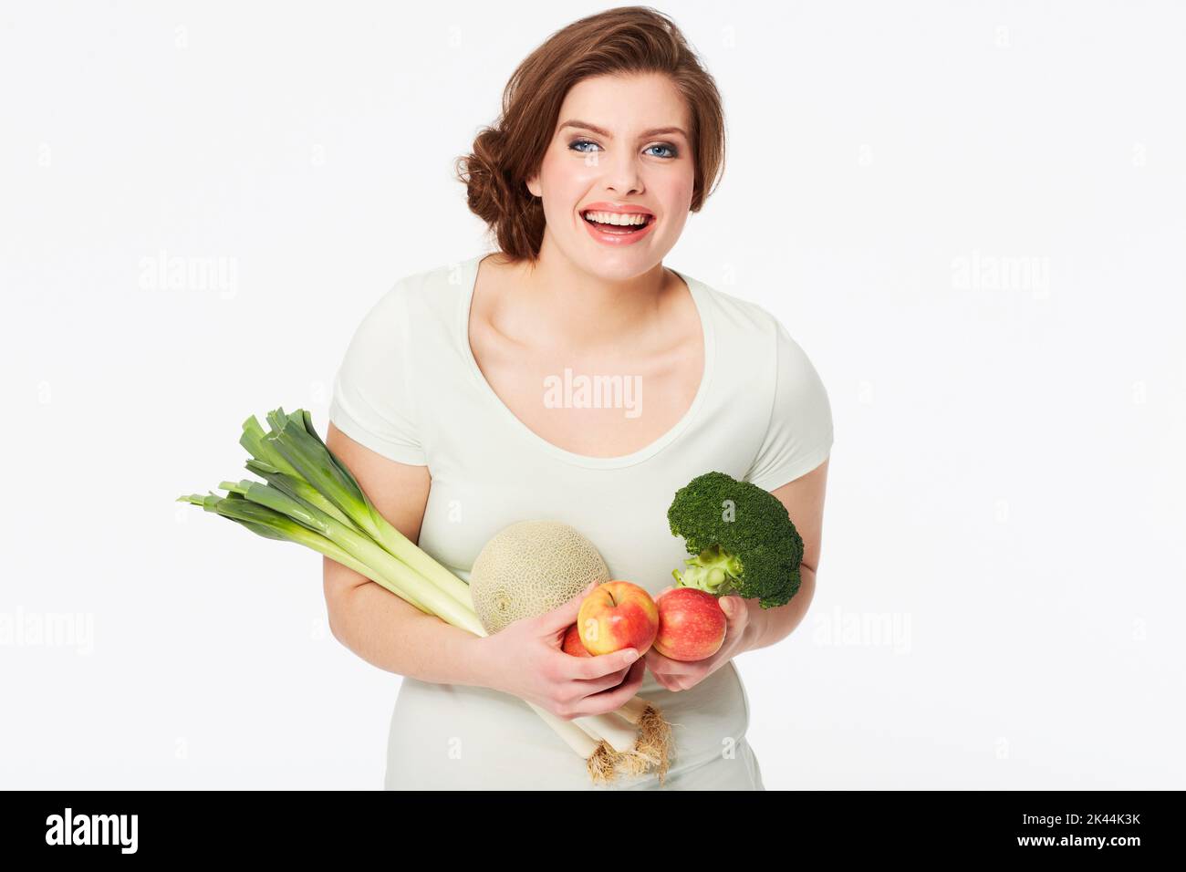 Bereit für eine gesunde Mahlzeit. Hübsche Brünette Frau hält einige gesunde Obst und Gemüse. Stockfoto