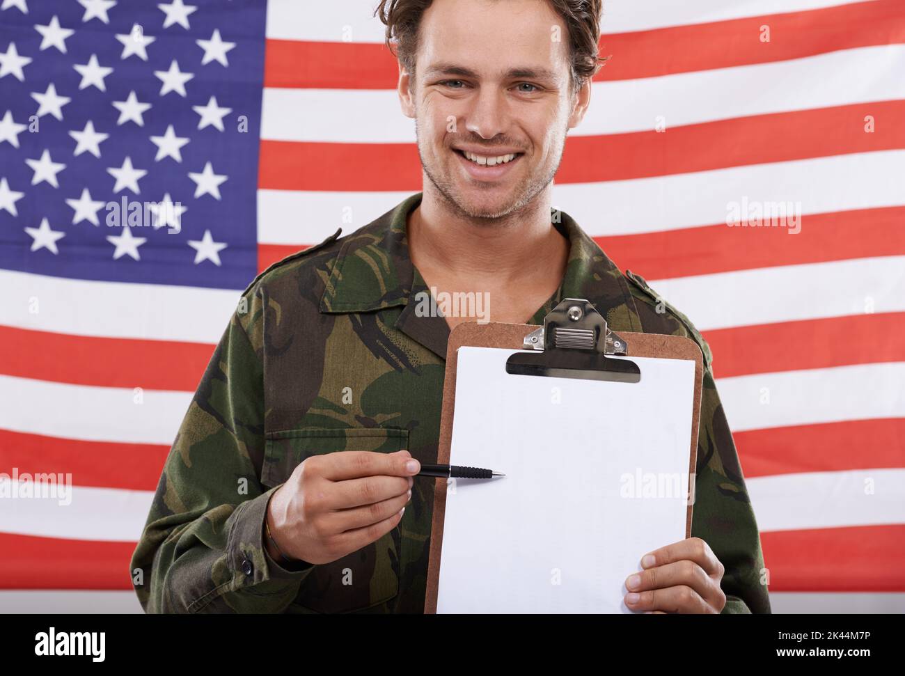 IVE registriert. Ein amerikanischer Soldat hält eine Zwischenablage vor der Flagge seines Landes. Stockfoto