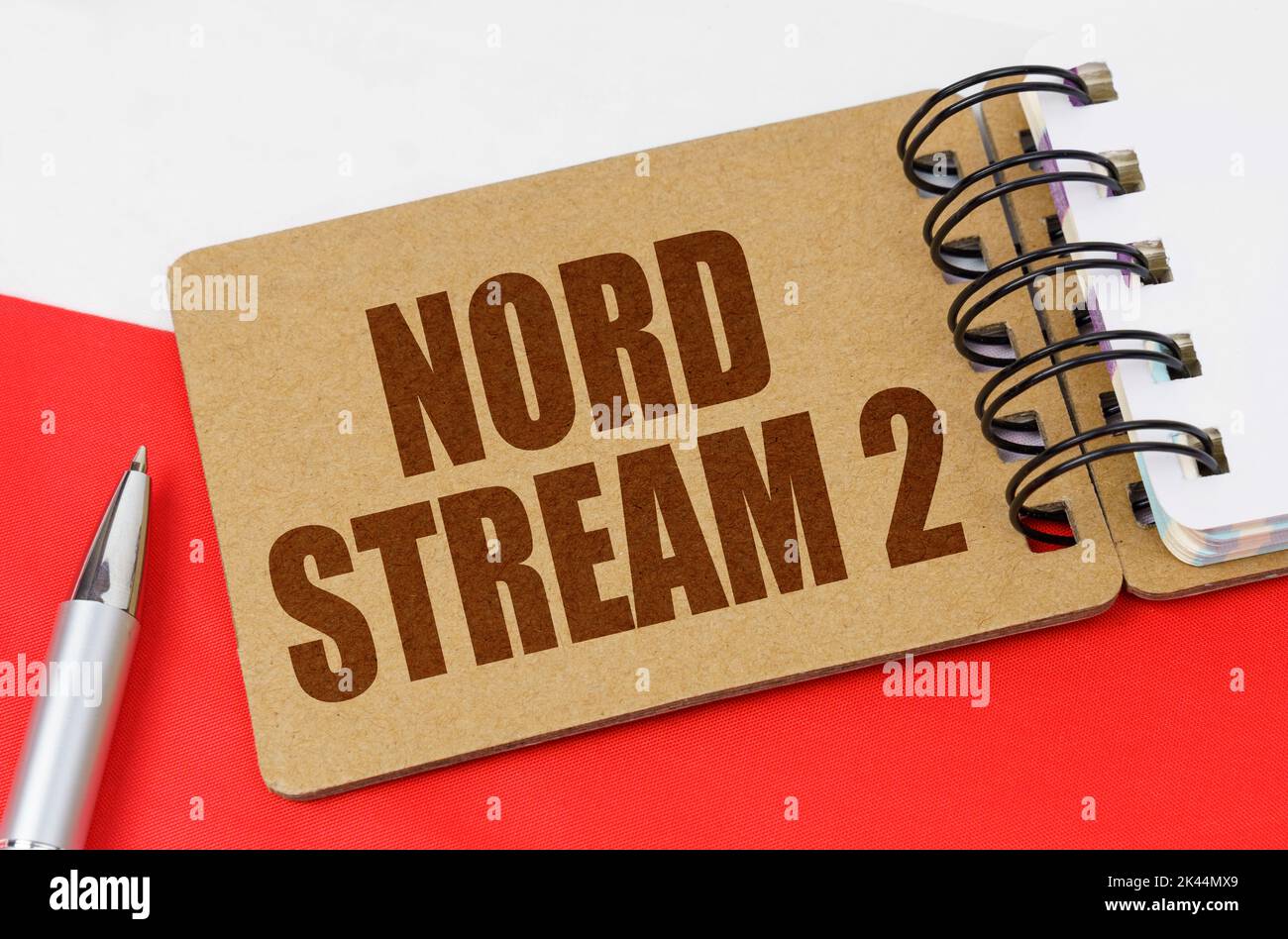 Konzept der nationalen Wirtschaft. Auf der polnischen Flagge steht ein Notizbuch mit der Aufschrift Nord Stream 2 Stockfoto