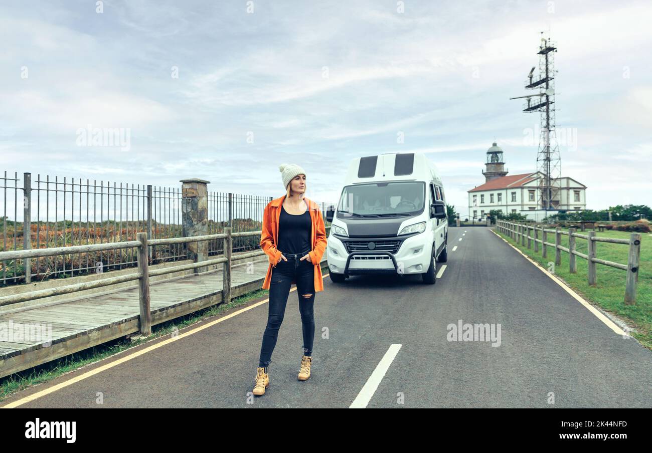 Frau posiert auf der Straße vor dem Wohnmobil Stockfoto