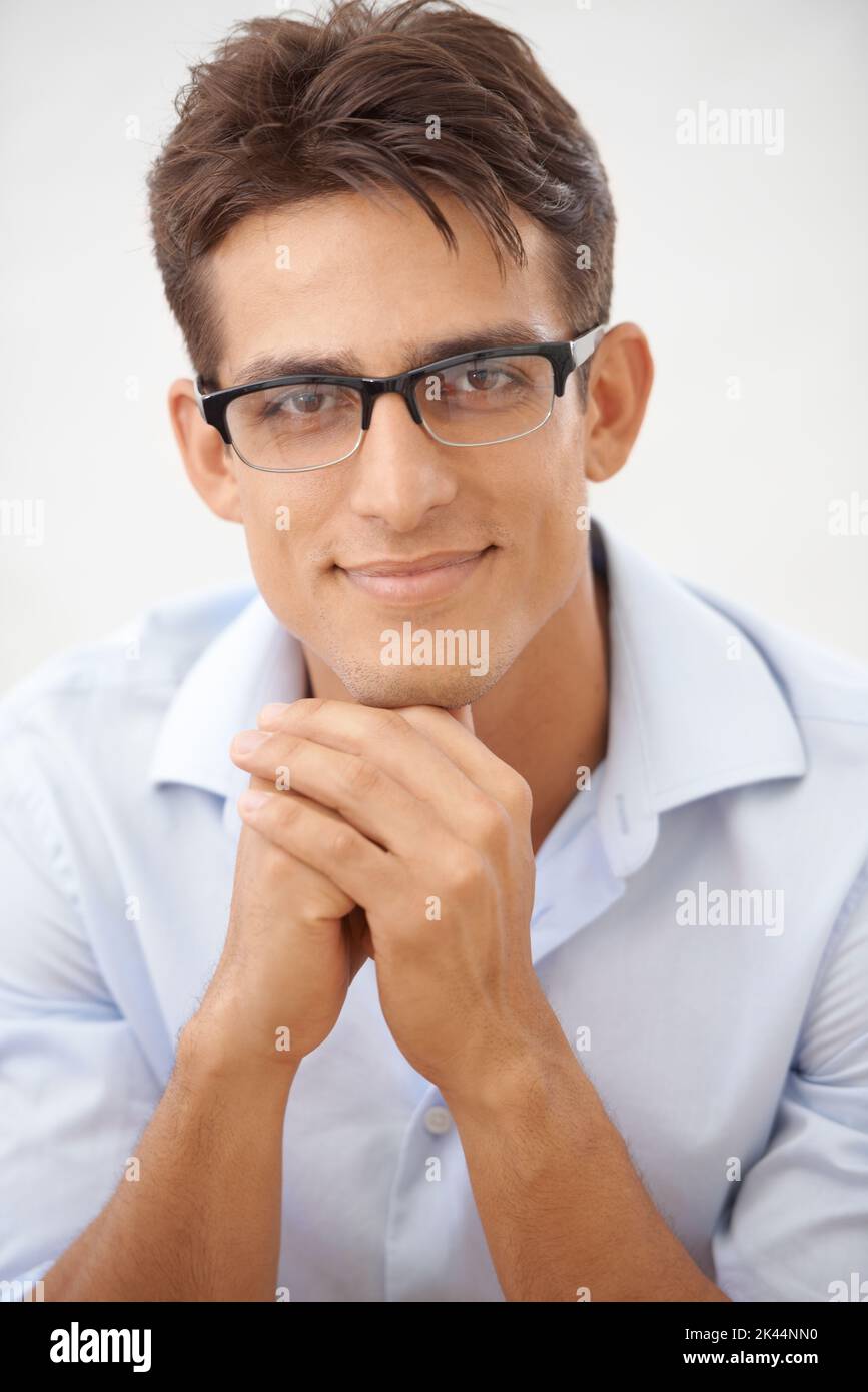 Handlich UND intelligent. Porträt eines hübschen jungen Geschäftsmannes, der eine Brille trägt und die Kamera anlächelt. Stockfoto