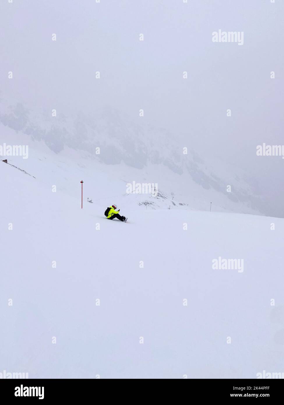 Ein Skifahrer saß auf Schnee und wartete auf einen milden Sturm Stockfoto