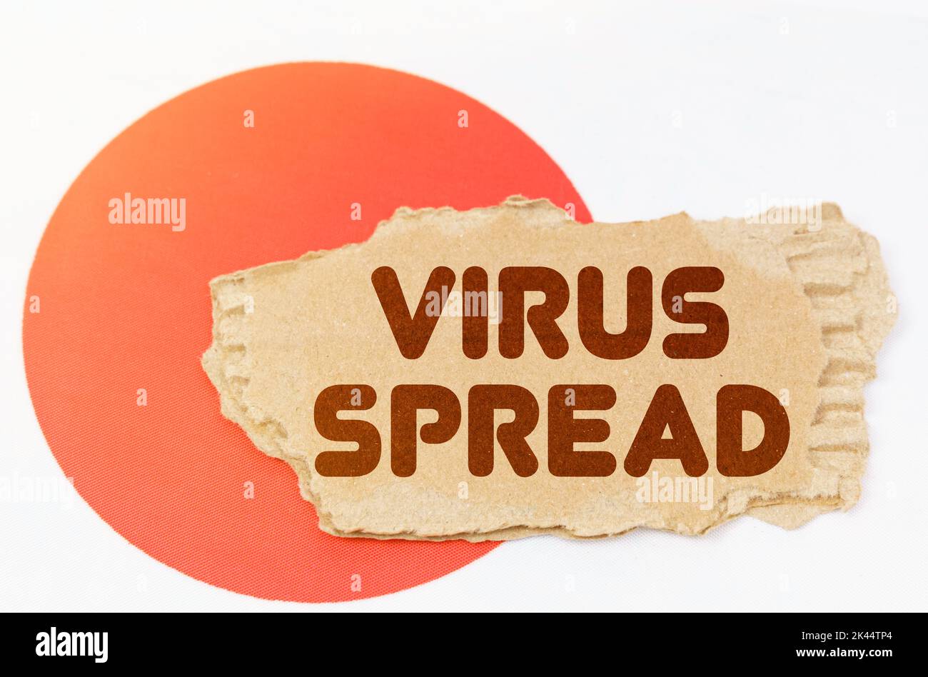 Konzept der nationalen Medizin. Auf der Flagge Japans liegt ein Notizbuch mit der Aufschrift - VIRUS SPREAD Stockfoto