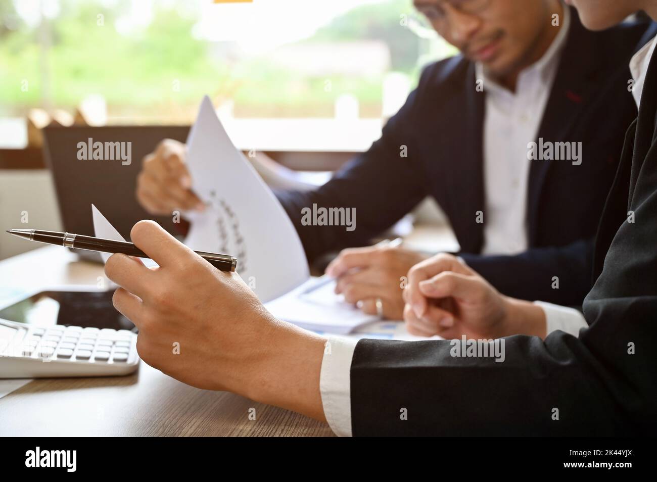 Professionelle und intelligente asiatische männliche Finanzberater analysieren Finanzdaten zum Bericht, treffen sich und arbeiten zusammen. Nahaufnahme und zugeschnittenes Bild Stockfoto